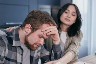 A couple experiencing stress and emotional distress at home, conveying empathy and support.